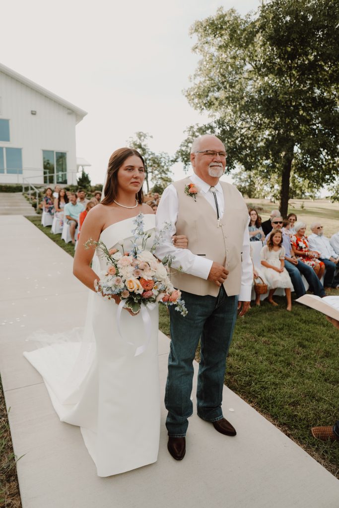 Father walks his daughter down Bella Rosa Venue's Tulsa outdoor ceremony site with skyline views